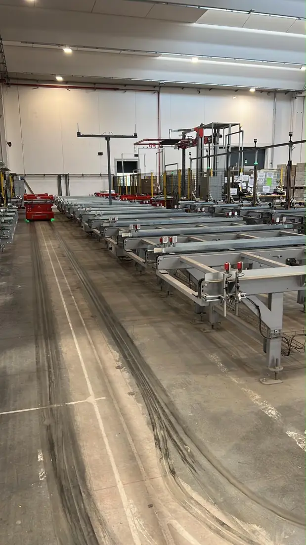Linea di trasporto a pavimento con carrello AGV in un magazzino automatizzato